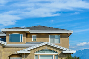A perfect neighborhood. Houses in suburb at Fall in the north America. Top of a luxury house with nice window over blue sky.
