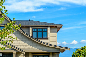A perfect neighborhood. Houses in suburb at Fall in the north America. Top of a luxury house with nice window over blue sky.