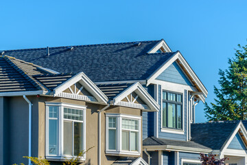 A perfect neighborhood. Houses in suburb at Fall in the north America. Top of a luxury house with nice window over blue sky.