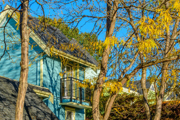 A perfect neighborhood. Houses in suburb at Fall in the north America. Top of a luxury house with nice window over blue sky.
