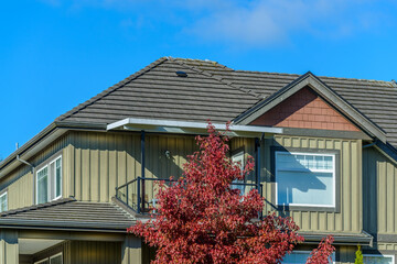 A perfect neighborhood. Houses in suburb at Fall in the north America. Top of a luxury house with...