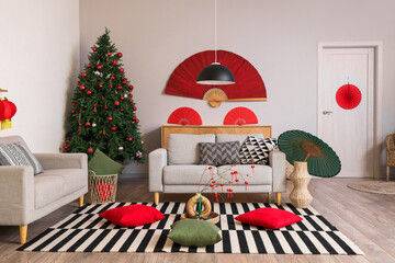 Interior of living room decorated for Japanese New Year celebration with sofas and fir tree