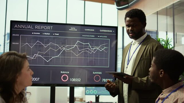 Coworkers engaging in a problem solving meeting at a corporation, using an interactive board to visualize data and develop solutions for complex challenges. Analysis presentation. Camera B.