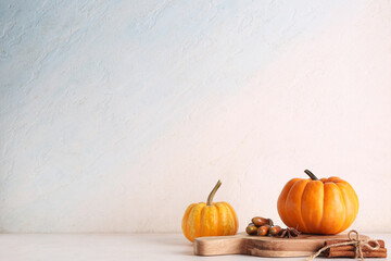 Wooden board with fresh pumpkins, acorns, star anise and cinnamon on white background