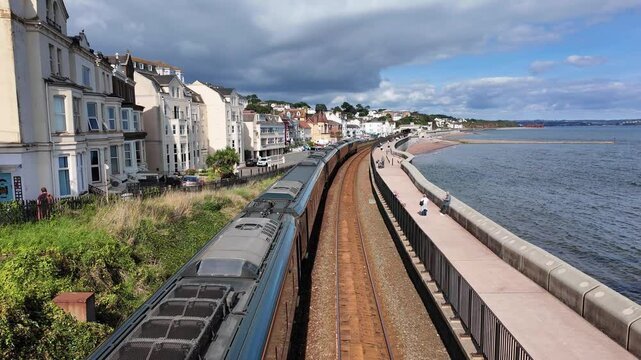 Dawlish Devon England. 01.10.2024. Video. Long passenger train approaching Dawlish railway station Devon, UK.