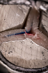 A close-up of a cut section of an armored power cable featuring three aluminum conductors, showcasing its detailed structure.