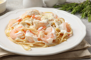 Delicious pasta with shrimps served on light table, closeup