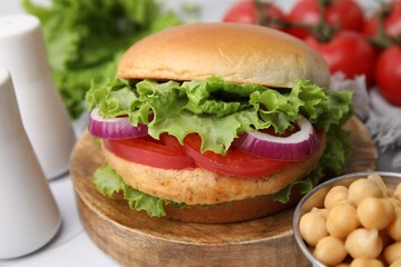 Delicious vegetarian burger with chickpea cutlet on table, closeup