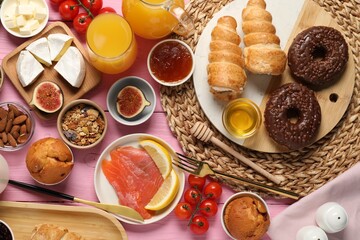 Different tasty food served for brunch on pink wooden table, flat lay