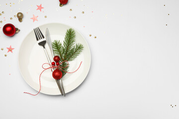 Christmas table setting with plate, cutlery and festive decor on white background, flat lay. Space...
