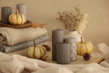 Grey candles and autumn decor indoors, closeup