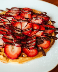 Plano detalle de un delicioso waffle de fresas chocolate