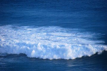 Turquoise ocean sea water white wave pattern splashing deep blue sea. Seascape dark ocean background wave splash on rock. Tropical sea beach in summer seaside outdoor. Water Surface blue wave pattern