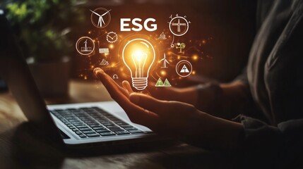 A person holding a glowing light bulb with the acronym ESG and various sustainability symbols. The light bulb represents a new idea or innovation for a more sustainable future.