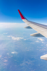 Obraz premium View from the airplane window at a beautiful cloudy sky and the airplane wing