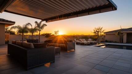 Fototapeta premium A sleek outdoor space features contemporary wicker furniture arranged beneath a stylish awning, illuminated by the warm glow of the setting sun casting long shadows