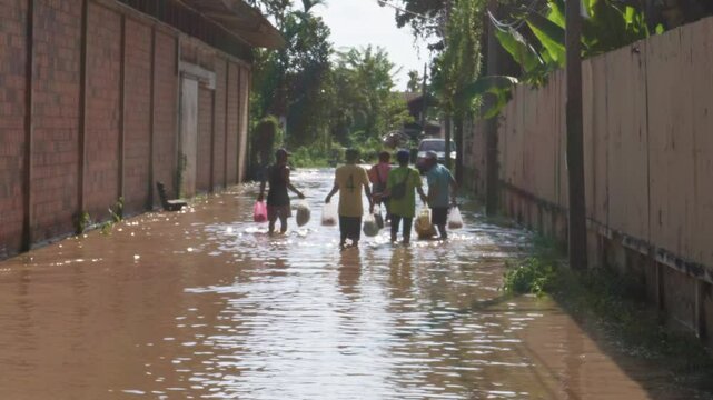 October 05, 2024 - Chiang Mai, Thailand: Severe flooding in residential areas of northern Thailand. Residents wade through flooded streets as rivers overflow during rush hour.