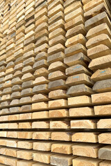 even stack of fresh thick boards in the warehouse.