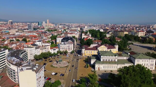drone shot, rising above Sofia, the capital city of Bulgaria, on a bright summer day with a clear blue sky. Above the Monument to the Tsar Liberator and old parliament building.