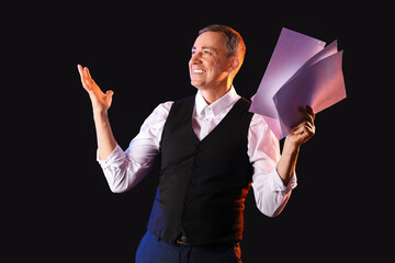 Mature actor with film script on dark background