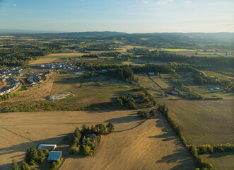 A large field with a few houses in the background