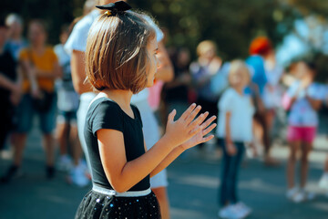 Little Girl Applauding at Outdoor Celebration. Enthusiastic cheerful kid feeling appreciation and positive emotions
