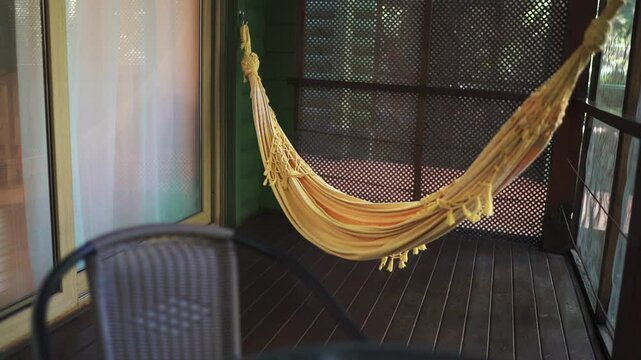 Yellow hammock is hanging on the terrace of a vacation rental room in the jungle. Argentina.