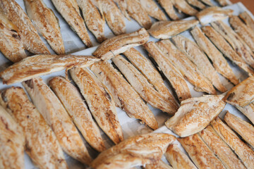 Dried fish filets are laying flat on a surface, carefully prepared for preservation and sale