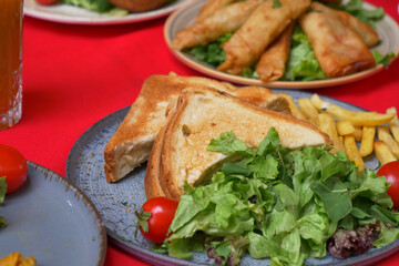 Enjoy a Delicious Meal featuring Toast, a Fresh Salad, and Crispy Spring Rolls on the Side