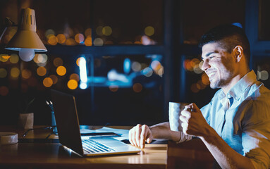Office Lifestyle. Happy Entrepreneur Sitting At Laptop Having Coffee At Workplace At Night. Free Space