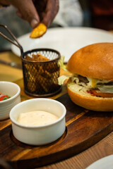 A picture of a chicken burger and potato chips with dip