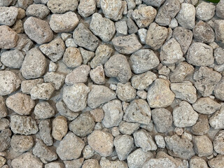 Natural bright coral pebbles stone, grey cobble pebbles for outdoor garden in seamless background texture.