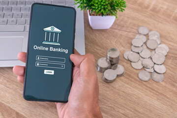 Male hand holding a smartphone to access online mobile banking. Enter username and password to...