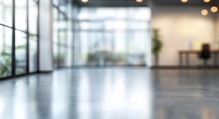 Fototapeta premium Blurred background of a modern office interior with glass windows and a polished concrete floor, providing ample copy space for text. 