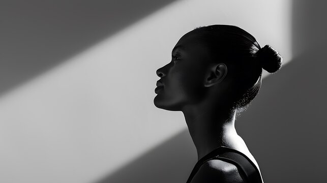 A moody black and white image of a model standing against a plain background, with dramatic high-contrast lighting casting long shadows behind. 8k UHD, suitable for high-quality printing or 