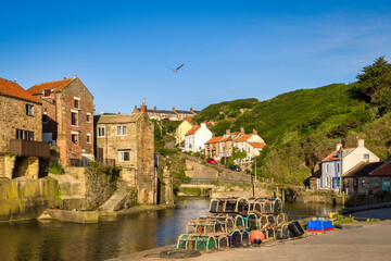 Naklejka premium Staithes, North Yorkshire, UK - Old fishing village of Staithes, at high tide on a summer morning.