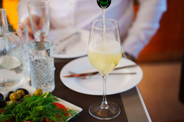 Champagne is poured into glasses on the banquet table. drink for the holiday