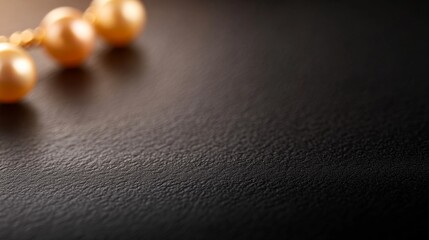 A pair of elegant gold pearl drop earrings is elegantly placed on a glossy black ceramic surface, illuminated by soft light to highlight its luxurious design and intricate details