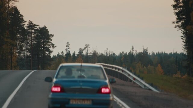 Retro car with single driver moves on the autumn asphalt road