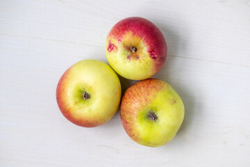 Fresh apples on a light wooden surface. Top view.