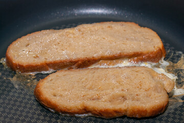 Bread Slices Frying in Egg Batter on a Pan