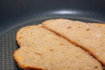 Bread Slices Frying in Egg Batter on a Pan