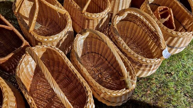 Handcrafted wicker baskets arranged outdoors on a grassy surface in natural sunlight