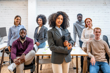 Female leader standing next to teamwork in a coworking