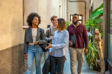 Colleagues walking out the coworking talking and smiling