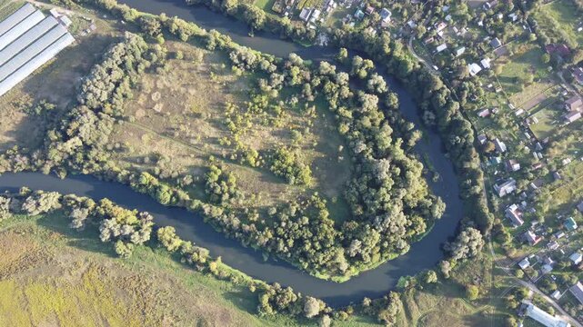 View from a great height of a river bed making a steep loop in the countryside. The Protva River in the Maloyaroslavets District
