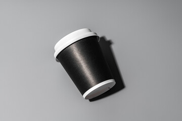 A minimalistic black coffee cup against a gray background