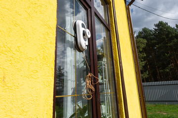 A window cleaner robot cleans windows in a house from the outside. Cleaning assistant, safe window cleaning, remote control
