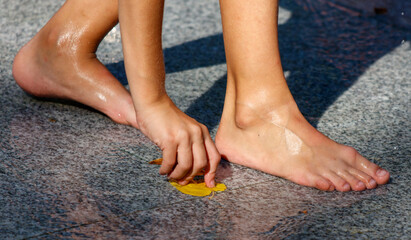 A person's feet are wet and they are holding a leaf