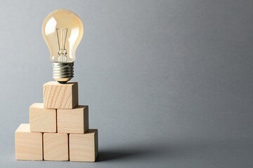 Light bulb on top of wooden blocks in the shape of stairs